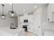 Modern kitchen with white cabinets, quartz countertops, and black appliances at 522 Sun Chaser Dr, Nokomis, FL 34275