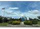 Community entrance with globe landmark and landscaping at 2386 Sumatran Way # 26, Clearwater, FL 33763