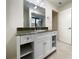 Bathroom vanity with granite counters, white cabinets, and mirror at 7483 Carnoustie Dr # 5B, Sarasota, FL 34238