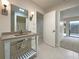 Bright bathroom featuring a single sink vanity with open shelving and a mirror at 7483 Carnoustie Dr # 5B, Sarasota, FL 34238
