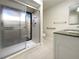 Bathroom featuring a glass-enclosed shower, granite vanity, and accessible grab bars at 7483 Carnoustie Dr # 5B, Sarasota, FL 34238