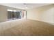Bedroom with carpet, ceiling fan, and large sliding glass door with access to the outside at 7483 Carnoustie Dr # 5B, Sarasota, FL 34238