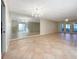 Spacious living room with tile flooring, large mirrors, and access to the patio at 7483 Carnoustie Dr # 5B, Sarasota, FL 34238