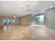 Spacious living room with tile flooring, modern light fixture, neutral color palette, and sliding glass doors at 7483 Carnoustie Dr # 5B, Sarasota, FL 34238