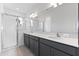 Bright bathroom featuring a double vanity, quartz countertop, and glass-enclosed shower at 9593 Vibrant Lane, Venice, FL 34292
