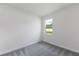 Simple bedroom with neutral carpet, white walls, and a window offering natural light at 9593 Vibrant Lane, Venice, FL 34292