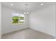 Minimalist dining area featuring a chandelier and large window with a green view at 9593 Vibrant Lane, Venice, FL 34292