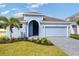 Charming single-story home with a blue exterior, arched entry, and well-manicured landscaping at 9593 Vibrant Lane, Venice, FL 34292