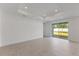 Bright and airy living room with neutral tones and sliding glass doors leading to the backyard at 9593 Vibrant Lane, Venice, FL 34292