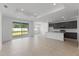 Open concept living room with kitchen and a sliding glass door leading to the outside at 9593 Vibrant Lane, Venice, FL 34292