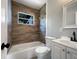 Cozy bathroom with a shower and tub, modern toilet and vanity, and attractive wood-look accent wall at 4011 Mesa Ave, Sarasota, FL 34233