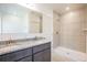 Bathroom featuring a double sink vanity with granite countertop and tiled walk-in shower at 5637 Ocarina Rd, North Port, FL 34291