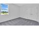 Bedroom with neutral paint, large window, carpet flooring and white double door closet at 9577 Vibrant Lane, Venice, FL 34292