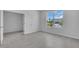 Bright bedroom with a large window offering a view of the lush landscaping outside at 9577 Vibrant Lane, Venice, FL 34292