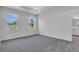 Bedroom with neutral paint, two large windows, carpet flooring and tray ceiling at 9577 Vibrant Lane, Venice, FL 34292