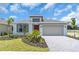 Charming single-Gathering home with a red door, landscaped yard, and a two-car garage at 9577 Vibrant Lane, Venice, FL 34292