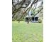 Charming blue house with a large front yard and mature trees at 34392 Broken Stone St, Webster, FL 33597