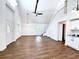 Open living room with vaulted ceilings, exposed beam, and wood floors at 34392 Broken Stone St, Webster, FL 33597