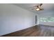 Bright bonus room with wood-look floors, a ceiling fan, and exterior access at 34392 Broken Stone St, Webster, FL 33597