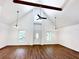 Open living room with vaulted ceilings, exposed beam, and wood floors at 34392 Broken Stone St, Webster, FL 33597