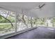 Bright screened porch with ceiling fan, overlooking a wooded area at 34392 Broken Stone St, Webster, FL 33597
