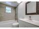 Updated bathroom with a white vanity, tile shower, and decorative mirror at 34392 Broken Stone St, Webster, FL 33597