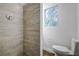 Bathroom with walk-in shower, toilet, and wood-look tile at 34392 Broken Stone St, Webster, FL 33597