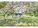 Quaint blue house nestled among large trees at 34392 Broken Stone St, Webster, FL 33597