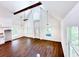 Open living area with vaulted ceiling, wood flooring, and large windows at 34392 Broken Stone St, Webster, FL 33597