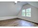 Spacious bedroom with sloped ceilings, a large window, and wood-look floors at 34392 Broken Stone St, Webster, FL 33597