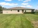 Well-maintained backyard with lush green grass, a neatly kept lawn, and a view of the home's exterior at 33083 Windelstraw Dr, Wesley Chapel, FL 33545
