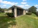 Screened-in lanai on the back of the home, surrounded by well-maintained green grass and a lush treeline at 33083 Windelstraw Dr, Wesley Chapel, FL 33545