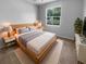 Bright bedroom featuring a large window and a comfortable wooden bed at 33083 Windelstraw Dr, Wesley Chapel, FL 33545