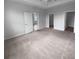 Spacious bedroom with neutral carpet, ample natural light, and multiple doorways at 33083 Windelstraw Dr, Wesley Chapel, FL 33545