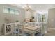 Bright dining area with wooden table and white chairs, adjacent to kitchen at 4915 Carova Way, Lakewood Ranch, FL 34211