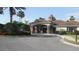 Community clubhouse with a covered entrance, manicured landscaping, and circular driveway at 11774 Tempest Harbor Loop, Venice, FL 34292