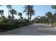 Community entrance featuring manicured landscaping, stone pillars, and elegant street lamps at 11774 Tempest Harbor Loop, Venice, FL 34292