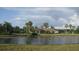 Scenic pond view with lush landscaping and palm trees, enhancing the natural beauty of the community at 11774 Tempest Harbor Loop, Venice, FL 34292