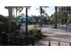 Resort-style pool area featuring palm trees, lounge chairs, umbrellas, and lush landscaping for relaxation at 11774 Tempest Harbor Loop, Venice, FL 34292