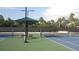 A pristine tennis court featuring a green and blue surface and shaded seating areas at 11774 Tempest Harbor Loop, Venice, FL 34292