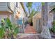 Brick pathway leads to a private backyard with tropical plants at 117 88Th Ave, Treasure Island, FL 33706