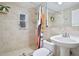 Updated bathroom with beige tile, shower/tub combo, and pedestal sink at 117 88Th Ave, Treasure Island, FL 33706
