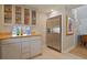 Kitchen with stainless steel refrigerator, glass-front cabinets, and wood countertop at 117 88Th Ave, Treasure Island, FL 33706