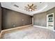 Spacious bedroom with ceiling fan and access to bathroom at 8235 Bird Whistle Ln, Land O Lakes, FL 34637