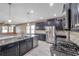Modern kitchen with granite countertops, stainless steel appliances, and dark cabinets at 8235 Bird Whistle Ln, Land O Lakes, FL 34637