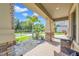 Inviting front porch with seating area, overlooking a landscaped yard and quiet street at 8235 Bird Whistle Ln, Land O Lakes, FL 34637