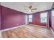 Spacious bedroom with purple walls and wood-look flooring at 8235 Bird Whistle Ln, Land O Lakes, FL 34637