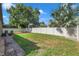 Spacious backyard with a large grassy area, privacy fence, and paver walkway at 8235 Bird Whistle Ln, Land O Lakes, FL 34637