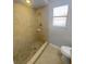 Bathroom featuring walk-in shower with beige tile, window, toilet and sink at 3184 Wessex Way, Clearwater, FL 33761