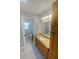 Bathroom with a vanity featuring a granite countertop, undermount sink, and an adjacent toilet room at 3184 Wessex Way, Clearwater, FL 33761